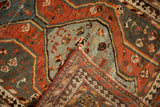 Folded corner of a Vintage Kamseh rug, revealing hand-knotted foundation, secured sides, and low pile.