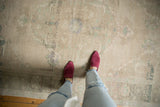 Low pile distressed Oushak carpet, faded beige, seafoam green, and brown patterns underfoot.
