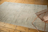 Muted beige Oushak carpet, distressed low pile with subtle medallion and finial details.