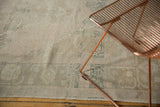 Low pile distressed Oushak rug, showing even wear and faded beige, sea foam green motifs.
