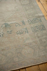 Distressed vintage Oushak low pile rug with faded beige and seafoam green patterns.