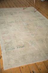 Textured low pile of a vintage distressed Oushak rug, with faded beige, green, and blue motifs.