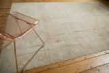 Distressed vintage Oushak rug texture, showing abrashed ivory, sand, and faint medallion outline.