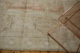 Distressed Oushak carpet with low pile, abrashed field, ivory, sand, blush tones, and fringe.