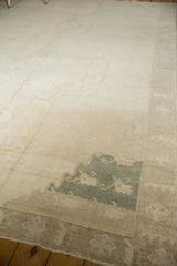 Distressed Oushak rug with low pile, abrash, and a faded green teal medallion detail.