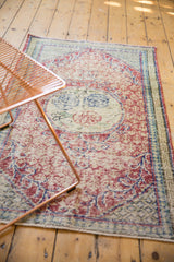 The soft, even wear on a distressed vintage Oushak rug showing its faded red and blue medallion.