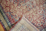 Corner of a distressed Oushak rug showing the hand-knotted back and evenly worn pile texture.