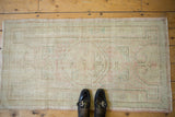 Textural corner of vintage distressed Oushak rug, with soft blush and mint green patterns.