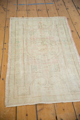Evenly worn knot heads showing faded roundel patterns on a distressed vintage Oushak rug.
