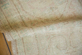 Distressed Oushak rug pile with visible even wear in ivory, pale blush, and mint green.