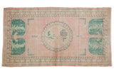 Distressed pink Oushak runner with central roundel, rose stem, and forest green laurel motifs.