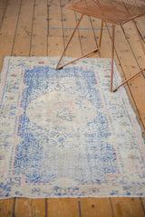 Distressed texture of the Oushak rug's roundel medallion with worn cobalt and ivory tones.