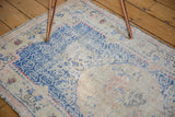 Distressed Oushak rug detail with worn pile and cobalt blue lattice pattern.