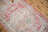 Distressed Oushak runner with foundation showing through, displaying pale cherry red, beige, and ivory.