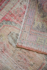 Distressed Oushak rug close-up: hand-knotted pile, wear to knot heads, visible foundation.