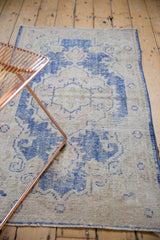 Distressed Oushak rug detail: worn pile, cobalt blue, ivory, and dusty rose rococo patterns.