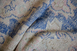 Vintage distressed Oushak rug with worn pile texture in cobalt blue and pale rose.