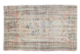 Distressed Turkish Oushak rug with oversized floral medallion in ivory, blush, and muted olive. 2'11