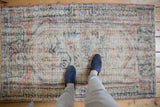 Distressed vintage Oushak rug showing even wear, with ivory, beige, and faded blush tones underfoot.