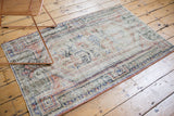 Distressed Oushak rug pile showing even wear, muted ivory, olive, and navy patterns.