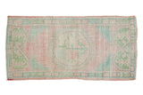 Faded pink and green distressed Oushak rug runner with a floral medallion, 2'1
