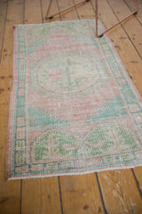Distressed texture and short ivory fringe at the end of the vintage Oushak runner.