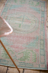 Vintage Oushak rug runner's distressed texture with faded pink, seafoam green, and blush tones.