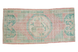 Distressed Oushak runner with faded pink field, seafoam green floral medallion, laurel leaf ends. 2'2