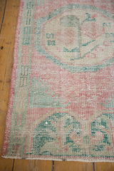 Distressed Oushak rug runner texture showing softened pink, seafoam green, and foundation wear.