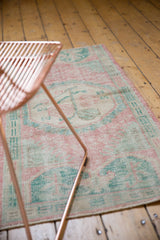 Distressed Oushak rug runner, with faded pink and seafoam green worn texture.