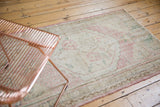 Worn texture of a traditional distressed Oushak rug with faded dusty rose patterns.