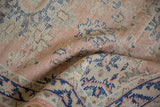 Distressed pile texture of Oushak rug, showing faint foundation through pale rose and blue.