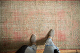 Distressed vintage Oushak rug showcasing faded blush, pink, and seafoam green pile.