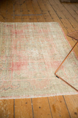 Vintage distressed Oushak rug showing even wear, visible foundation, blush pink, seafoam green.