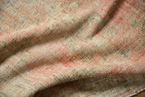 Distressed texture of vintage Oushak rug pile, with even wear and visible foundation.