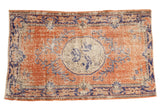 Distressed vintage Oushak rug, dusty rust terra cotta field, cobalt blue vinery, ivory medallion.