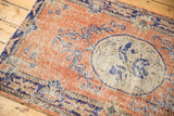 Distressed Oushak rug detail: rustic terra cotta field, cobalt vinery, ivory medallion texture.