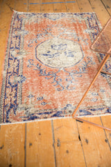 Distressed Oushak rug showing even wear, rusty terra cotta, cobalt blue, and ivory.