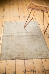 Vintage Oushak rug's secured end with short fringe and textured beige pile.