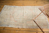Vintage distressed Oushak rug texture with visible foundation wear, muted blush, beige, and blue patterns.
