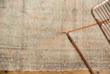 Distressed Oushak rug pile detail, showing exposed knot heads, muted beige, blush, and blue.