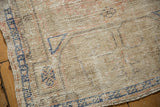 Close-up of distressed Oushak rug corner, showing even pile wear and cobalt blue border.
