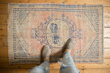 Distressed vintage Oushak rug, faded blush and blue central medallion with low pile.