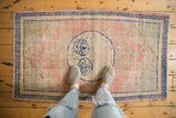 Distressed Oushak rug detail: cobalt blue border, blush pink field, and visible even wear.