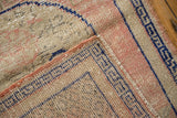 Distressed Vintage Oushak rug, showing knot heads and a geometric cobalt blue border.