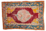 Antique Anatolian rug with a central roundel medallion, cherry red field, and brightly colored spandrels.