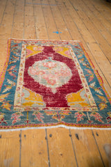 Angled view displaying the full antique Anatolian rug's medallion and colorful spandrels.