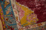 Even wear across the knot heads on an antique Anatolian rug's brightly colored corner spandrel.