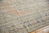 Distressed vintage Oushak carpet pile with faded blush, ivory, and denim blue florals.