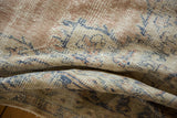 Distressed vintage Oushak carpet detail showing blush, ivory, denim blue, and faint foundation.